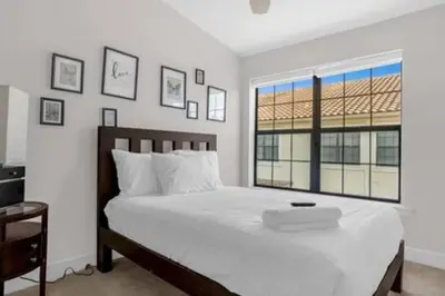 a bedroom with a large white bed and a window at Perfect Summer Escape - Townhome by Disney in Orlando