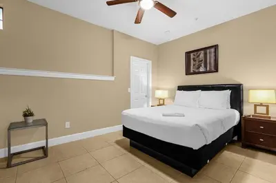 a bedroom with a large bed and a ceiling fan at Florida Summer - Townhome 5 min from Disney in Orlando