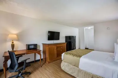 a hotel room with a bed and a desk with a computer at Hotel O Orlando Airport near Florida Mall in Orlando