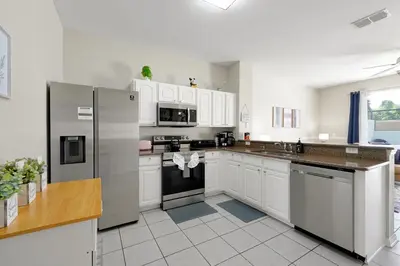 a kitchen with white cabinets and stainless steel appliances at Windsor Hills Resort - Water Park - Private Heated Plunge Pool - Near Disney in Orlando