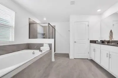 a white bathroom with a tub and a sink at Stunning 7BR Resort Pool Home 13 Min Disney in Kissimmee