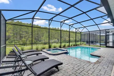 a glass greenhouse with chairs and a swimming pool at Stunning 7BR Resort Pool Home 13 Min Disney in Kissimmee