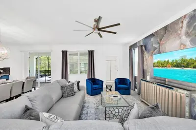 a living room with a couch and a tv at Stunning 7BR Resort Pool Home 13 Min Disney in Kissimmee