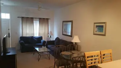 a living room with a couch and a table and chairs at Townhome Near Disney Mid Term rentals Welcome in Kissimmee