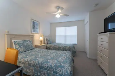 a bedroom with two beds and a tv and a dresser at Townhome Near Disney Mid Term rentals Welcome in Kissimmee