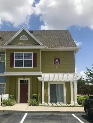 a green house with a sign on it at Beautiful Townhome In a Resort Near Disney in Kissimmee