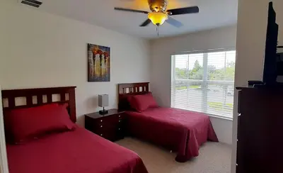 a bedroom with two beds and a ceiling fan at Beautiful Townhome In a Resort Near Disney in Kissimmee