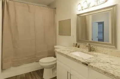 a bathroom with a toilet and a sink and a mirror at Beautiful Townhome In a Resort Near Disney in Kissimmee