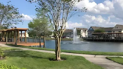 a fountain in the middle of a lake with houses at Beautiful Townhome In a Resort Near Disney in Kissimmee