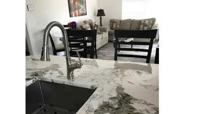 a kitchen with a marble counter top and a sink at Beautiful Townhome In a Resort Near Disney in Kissimmee