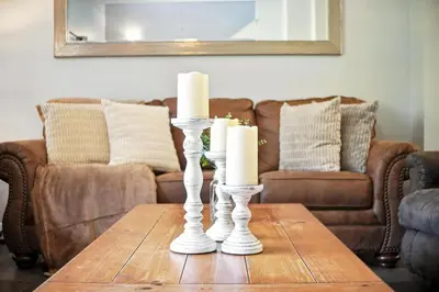 two white candles on a wooden table in a living room at Family Getaway Near Clubhouse and Community Pool 5 miles from Disney in Kissimmee