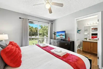 a bedroom with a large bed and a balcony at Family Getaway Near Clubhouse and Community Pool 5 miles from Disney in Kissimmee