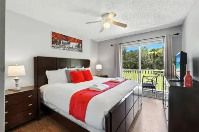a bedroom with a large bed and a balcony at Family Getaway Near Clubhouse and Community Pool 5 miles from Disney in Kissimmee