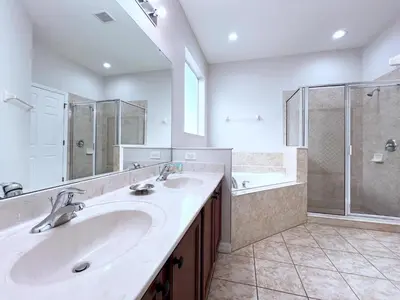 a bathroom with two sinks and a shower at Disney Getaway Villa with Private Pool Hot Tub. Book Now VP140 in Kissimmee