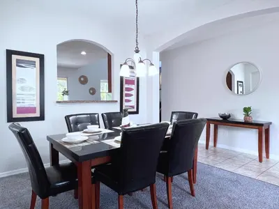 a dining room with a table and black chairs at Disney Getaway Villa with Private Pool Hot Tub. Book Now VP140 in Kissimmee