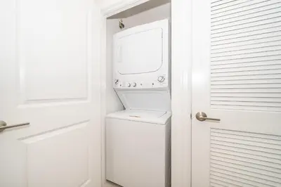 a white laundry room with a washer and dryer at Disney Getaway Luxury Condo with Private Balcony. Book Now SLR366 in Kissimmee