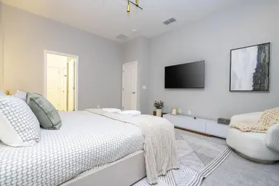 a white bedroom with a bed and a tv on the wall at Disney Private Pool Game Room Themed Bedrooms. Book Now PG25 in Orlando