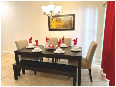 a dining room table and chairs with red cards on it at Disney Getaway Townhouse with Private Pool. Book Now SLR484 in Kissimmee