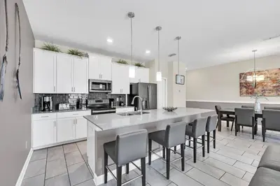 a kitchen with white cabinets and a table with chairs at Disney Getaway Private Pool Themed Bedrooms. Book Now SLR1162 in Kissimmee