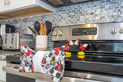 a kitchen counter with an oven with apron on it at Disney Getaway Private Pool Themed Bedrooms. Book Now SLR410 in Kissimmee