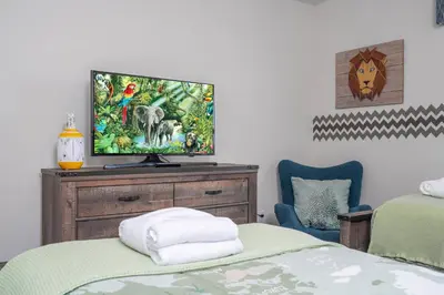 a bedroom with a bed and a tv on a dresser at Disney Getaway Private Pool Themed Bedrooms. Book Now SLR410 in Kissimmee