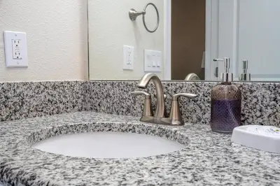 a bathroom counter with a sink and a mirror at Disney Getaway Private Pool Themed Bedrooms. Book Now SLR410 in Kissimmee