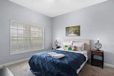 a bedroom with a large bed and a window at Disney Getaway Townhouse with Private Pool. Book Now SLR476 in Kissimmee