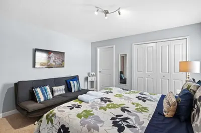 a bedroom with a bed and a couch at Disney Getaway Townhouse with Private Pool. Book Now SLR476 in Kissimmee