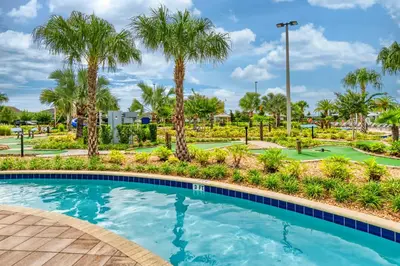 a swimming pool with palm trees in a resort at Disney Getaway Townhouse with Private Pool. Book Now SLR476 in Kissimmee