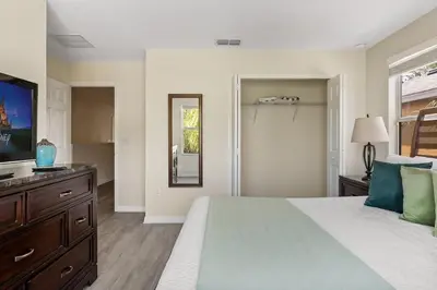 a bedroom with a large bed with a dresser and a mirror at Disney Getaway Luxury Villa with Private Pool. Book Now BV75 in Kissimmee