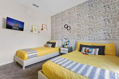 a bedroom with two beds and a brick wall at Disney Getaway Private Pool Themed Bedrooms. Book Now SLR503 in Kissimmee