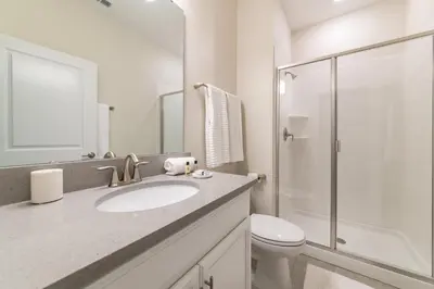 a white bathroom with a sink and a toilet at Disney Getaway Private Pool Themed Bedrooms. Book Now SLR377 in Kissimmee