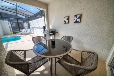 a table and chairs in a room with a pool at Disney Getaway Private Pool Themed Bedrooms. Book Now SLR377 in Kissimmee
