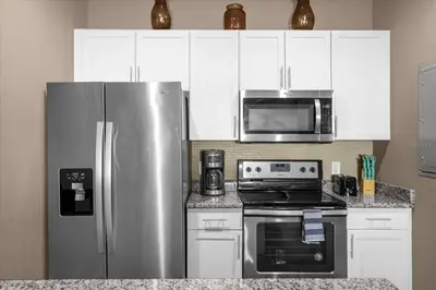 a kitchen with a stainless steel refrigerator and microwave at Disney Getaway Townhouse with Private Pool. Book Now WLV82 in Kissimmee