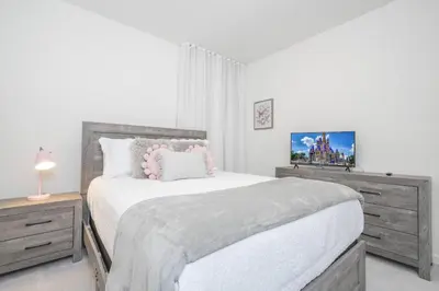 a white bedroom with a large bed and a dresser at Disney Getaway Private Pool Themed Bedrooms. Book Now BV241 in Kissimmee