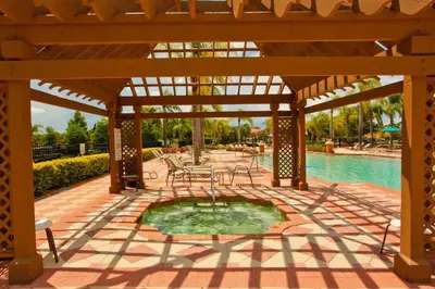 a pavilion with a pool and a table and chairs at Disney Private Pool Hot Tub Themed Bedrooms. Book Now BV76 in Kissimmee