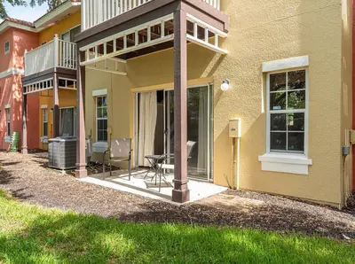 a patio of a house with a table and chairs at Disney Getaway Townhouse with Private Pool. Book Now EIR68 in Kissimmee