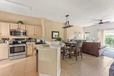 a kitchen and living room with a table and a couch at Disney Getaway Townhouse with Private Pool. Book Now EIR68 in Kissimmee