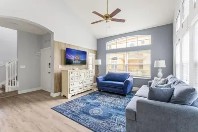a living room with a blue couch and a tv at Disney Getaway Private Pool Themed Bedrooms. Book Now EIR67 in Kissimmee