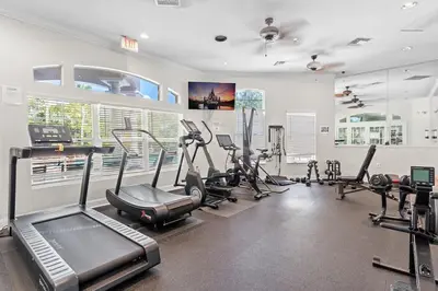 a gym with several treadmills and cardio machines at Disney Getaway Private Pool Themed Bedrooms. Book Now EIR67 in Kissimmee
