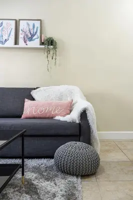 a living room with a grey couch with a pink pillow at Disney Getaway Private Pool Themed Bedrooms. Book Now LV8 in Kissimmee