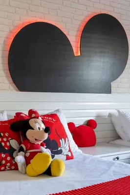 a stuffed animal sitting on a bed with red pillows at Disney Getaway Private Pool Themed Bedrooms. Book Now LV8 in Kissimmee