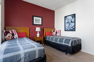 a bedroom with two beds and a red wall at Disney Getaway Private Pool Themed Bedrooms. Book Now LV7 in Kissimmee
