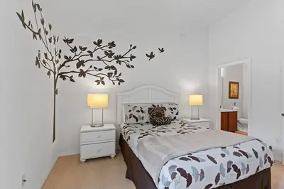 a bedroom with a bed with a tree on the wall at Disney Getaway Luxury Villa with Private Pool Game Room. Book Now VP48 in Kissimmee