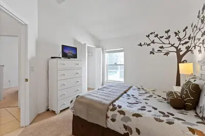 a bedroom with a bed with a tree on the wall at Disney Getaway Luxury Villa with Private Pool Game Room. Book Now VP48 in Kissimmee