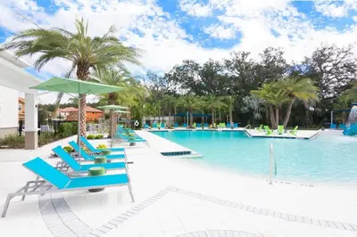 a pool with blue lounge chairs and an umbrella at Disney Getaway Luxury Villa with Private Pool Game Room. Book Now VP48 in Kissimmee