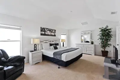 a bedroom with a large bed and a couch at Disney Getaway Luxury Villa with Private Pool Game Room. Book Now VP48 in Kissimmee
