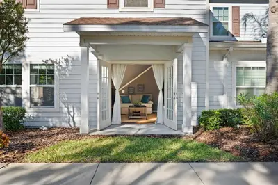 a white house with an entrance to a porch at Disney Getaway Private Pool Themed Bedrooms. Book Now WLV19 in Kissimmee