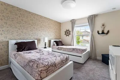 a bedroom with two beds and a window at Disney Getaway Private Pool Themed Bedrooms. Book Now SLR506 in Kissimmee