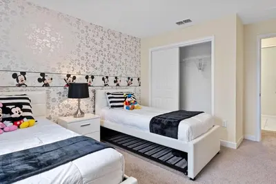 a bedroom with two beds and a wall with wallpaper at Disney Getaway Private Pool Themed Bedrooms. Book Now SLR506 in Kissimmee